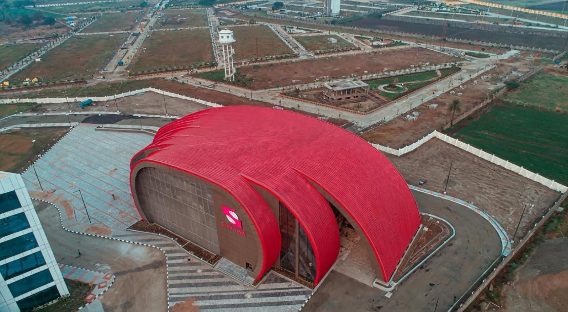 A large building with a red curved metal roof